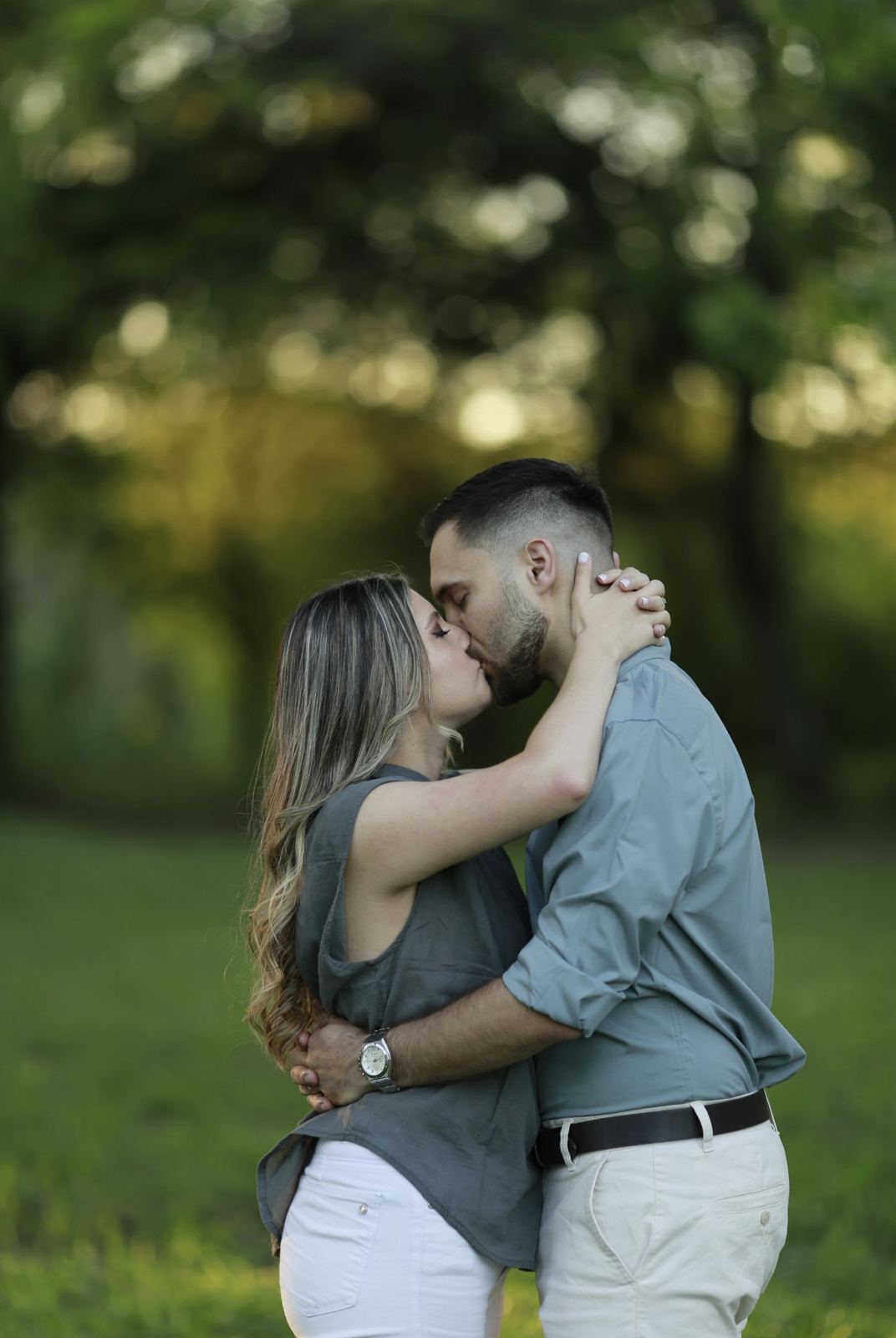 Los novios besándose bajo los árboles