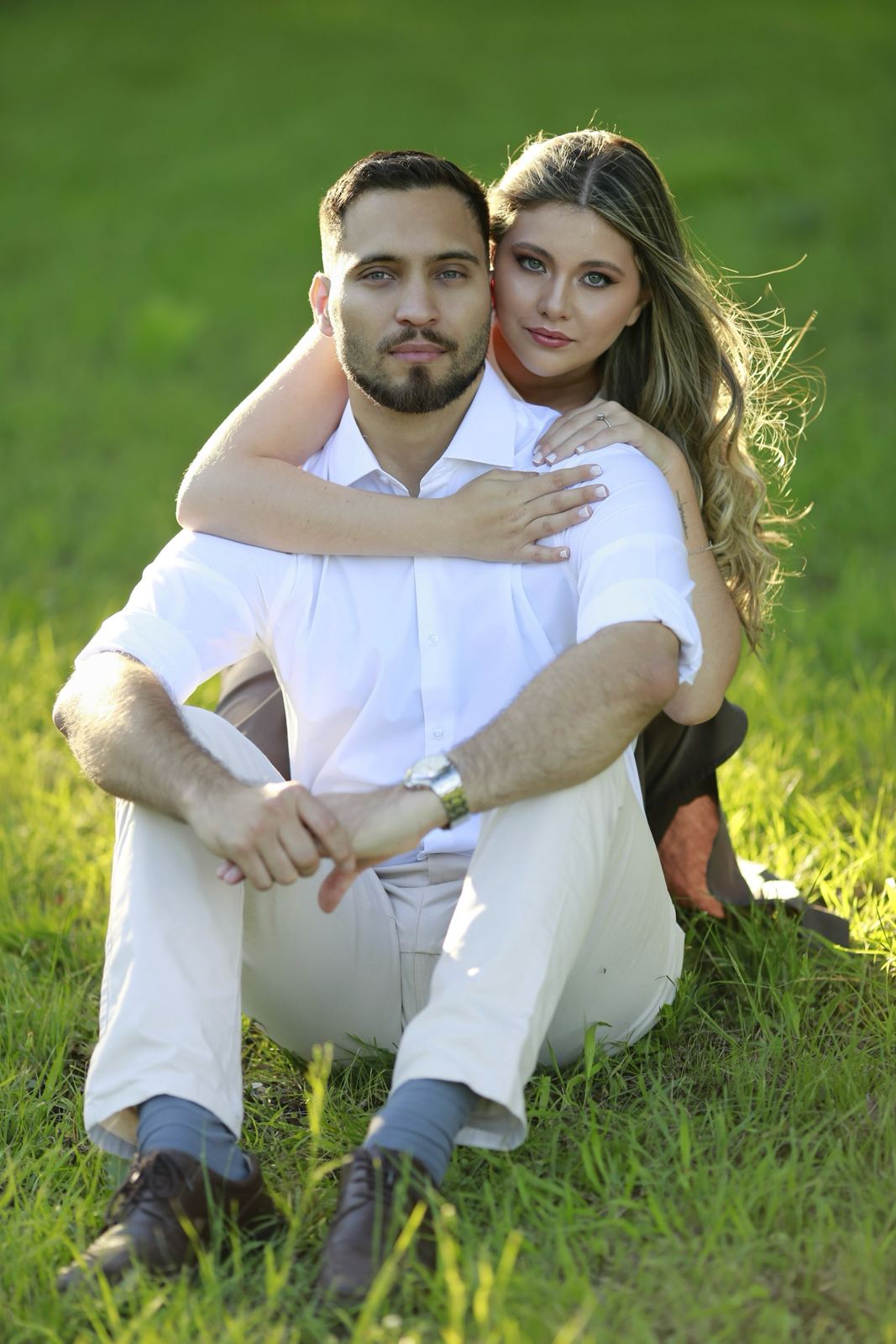 Los novios sentados en el pasto, abrazados